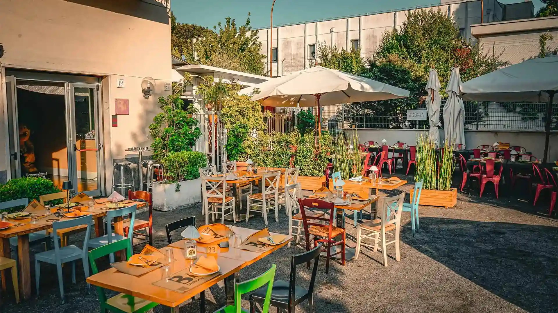 Esterno del ristorante con tavoli apparecchiati in una ampia piazza